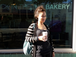 Tamara Angela Grant standing in front of a bakery holding a drink