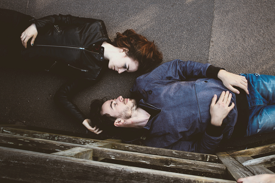 Dating tips for women: Woman and man laying on the ground gazing at each other. 