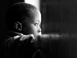 African American boy staring out of a window