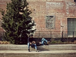 Man and woman sitting on the side of a building spending intimate time without sexual foreplay