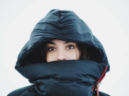 Woman wearing a big black jacket because of the icy-cold temperature