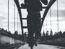 woman running on a bridge in the rain