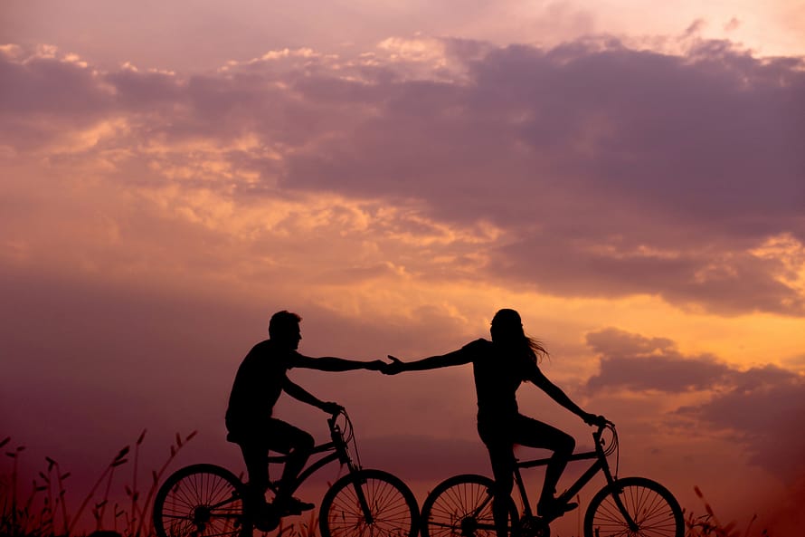 Woman and man riding bicycles together